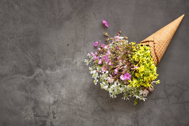 Stożek lodowy wypełniony świeżymi kwiatami dzikich kwiatów - Zdjęcie, obraz