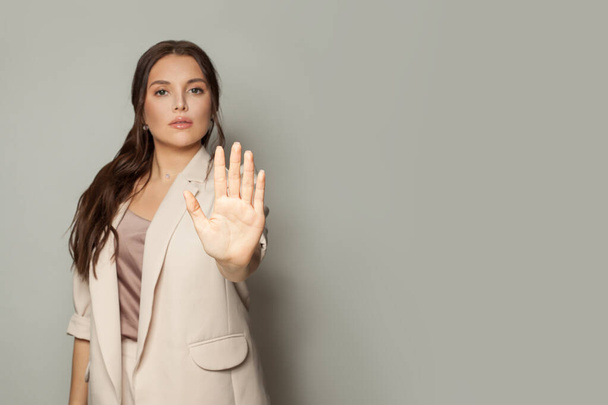 Mulher de negócios inteligente mostrando parar gesto em fundo banner cinza - Foto, Imagem