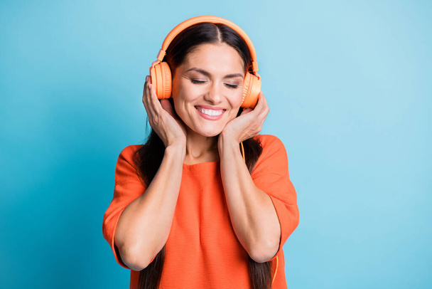 Portrait of pretty person hands touch headphones closed eyes good mood isolated on blue color background - Foto, Bild
