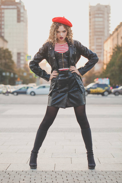 Fashion portrait of young woman in black leather jacket and red beret posing on the street  - Φωτογραφία, εικόνα