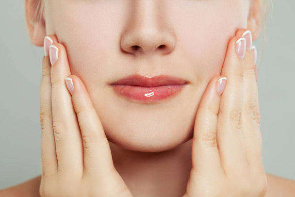 Manicure. vrouw aanraken van haar gezicht haar hand met gemanicuurde nagels - Foto, afbeelding