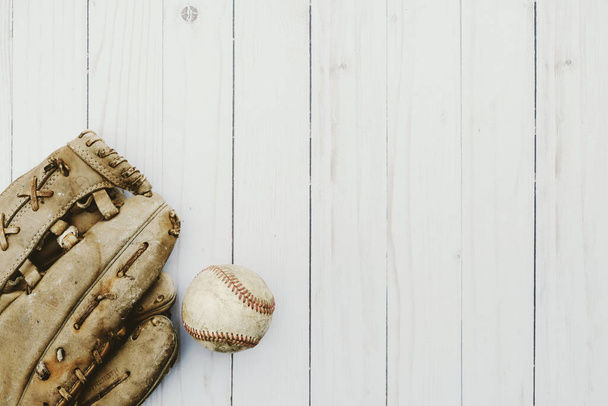Old baseball glove with ball for sports flat lay on white wood background. - Zdjęcie, obraz