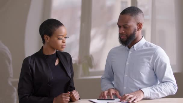 African woman at negotiating meeting in office with afro male financial consultant real estate agent businessman manager business partner signing paper document purchase contract partnership agreement - Footage, Video