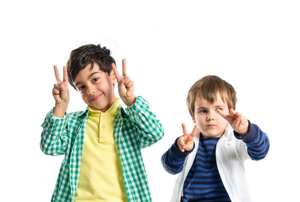 Boys making victory sign over white background  - Photo, Image