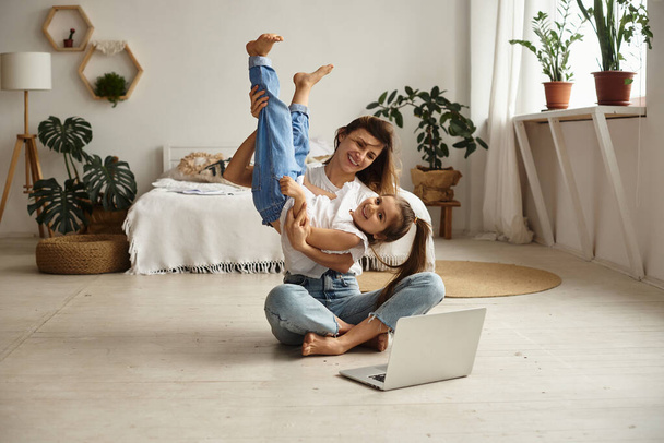 Daughter plays with mom and cat while mom works on computer - Foto, immagini