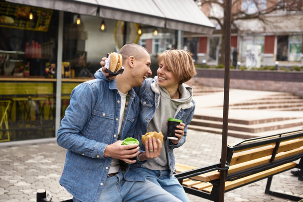 young couple drinking coffee while walking around the city - Foto, Bild