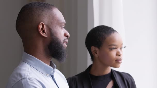 Két üzlettárs kollégák felnőtt afrikai férfi és fiatal nő áll hivatalban néz ki ablak tervezési munkastratégia. Etnikai vegyes faj fekete pár gondolkodik gondolkodás jövő ötletek - Felvétel, videó