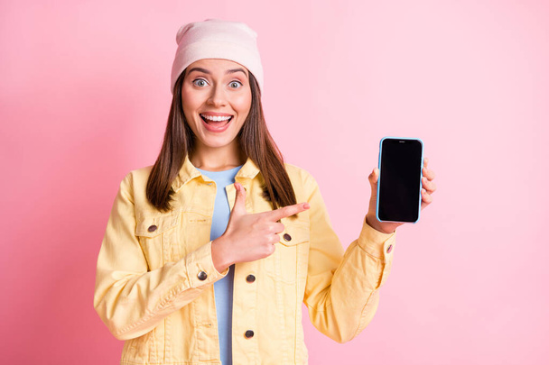 Photo of attractive impressed lady great proposition finger indicate phone isolated on pink color background - Zdjęcie, obraz