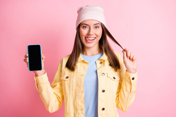 Portrét rozkošné okouzlující dáma jazyk ven lízat ret ruční držení telefonu izolované na růžovém pozadí - Fotografie, Obrázek