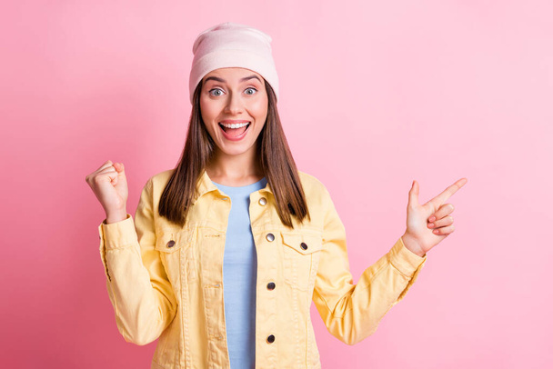 Photo of happy amazed brown haired woman raise fist point empty space subscribe isolated on pink color background - Фото, изображение