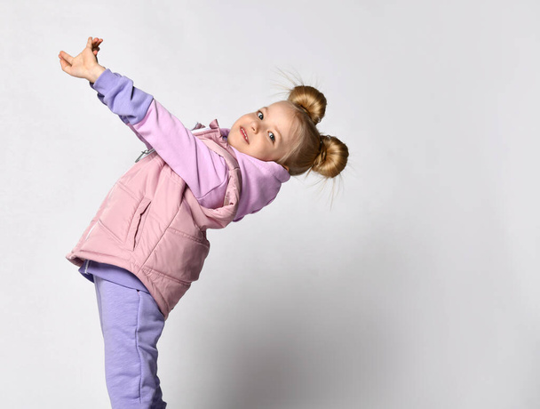 Girl in pink violet color sportive outwear posing for camera studio shot - 写真・画像