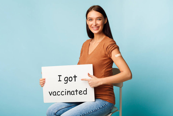Senhora grávida segurando cartaz eu fui vacinado em fundo azul - Foto, Imagem
