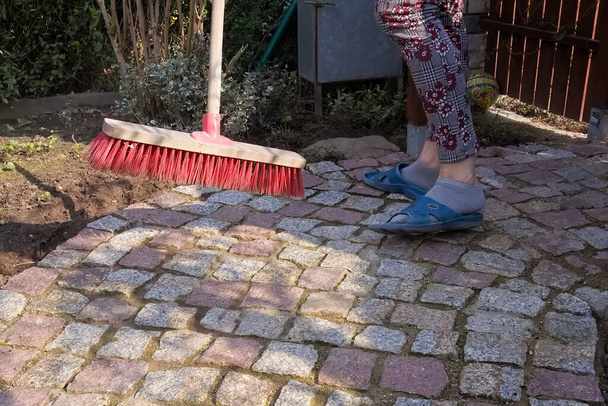 Barrer un camino de pavimentación de granito en el jardín de primavera - Foto, Imagen