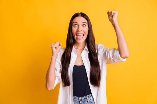 Photo of astonished positive lady raise fists up open mouth celebrate isolated on yellow color background - Foto, Bild
