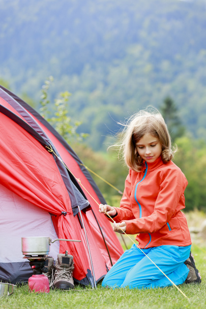 Camp in the tent - young girl setting a tent on the camping - Fotografie, Obrázek