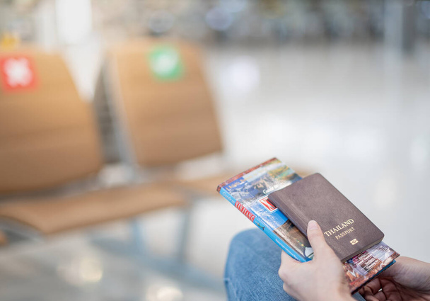 Libro de pasaportes y guía de viaje para mujeres en el aeropuerto, debido al concepto de pandemia epidémica de Covid-19. - Foto, imagen