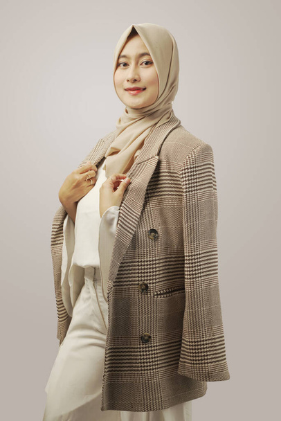 Portrait of beautiful trendy woman with hijab in suit or coats isolated on white - 写真・画像
