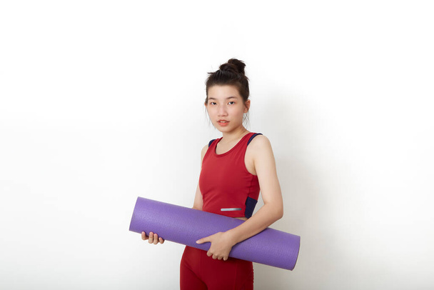exercise fitness Thai Asian woman ready for workout standing holding yoga mat on white background - Foto, imagen