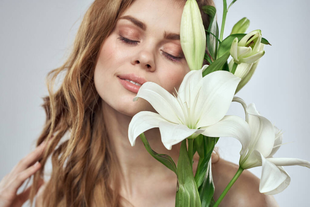 Encantadora dama con flores blancas retrato primer plano fondo claro - Foto, imagen