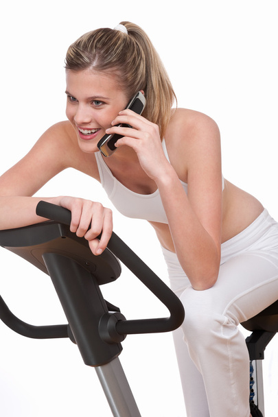 Fitness-sarja - Nainen, jolla on matkapuhelin valkoisella taustalla
 - Valokuva, kuva