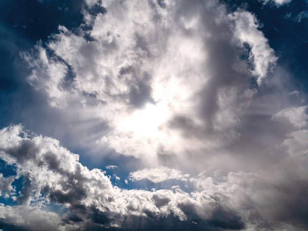 Sun rays shining through the clouds on the blue sky. - Photo, Image