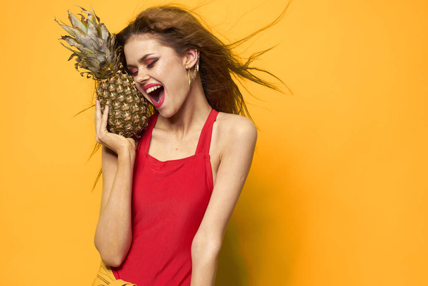 woman with pineapple in hands white t-shirt Exotic summer fun yellow background - Photo, Image