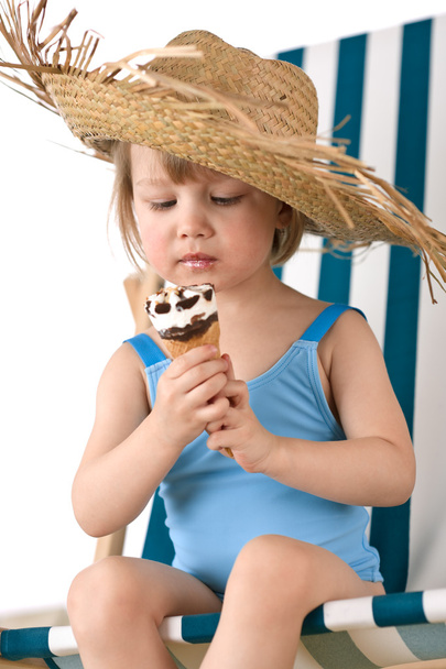 Beach - Little girl on deck-chair with straw hat and ice-cream cone - Foto, imagen