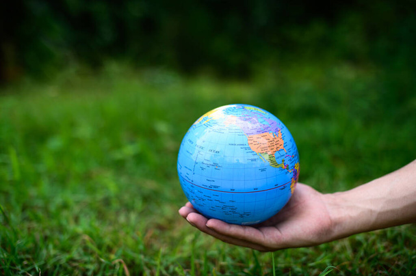 Día Mundial del Medio Ambiente .Love el mundo .Hand sosteniendo un globo - Foto, imagen