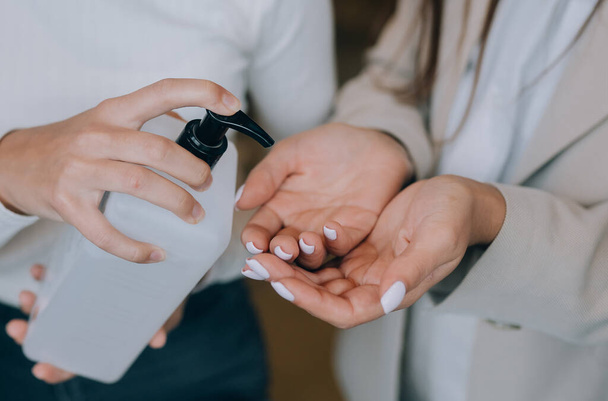 Mani femminili che applicano sapone liquido antibatterico da vicino. - Foto, immagini