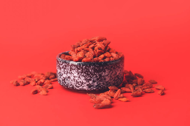 Bowl with dried goji berries on color background - Foto, Imagem