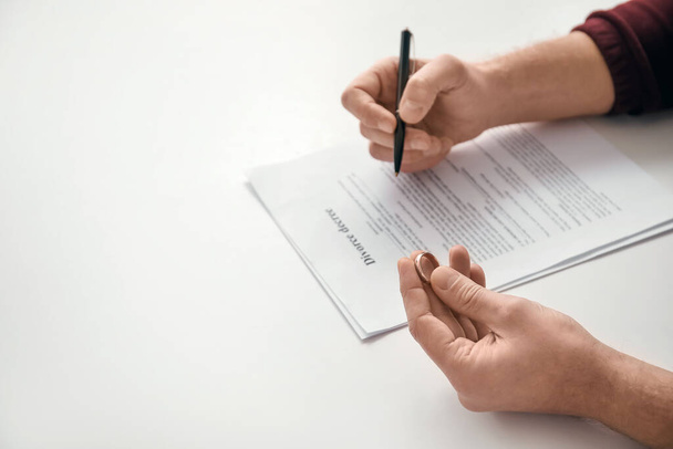 Man signing decree of divorce in lawyer's office, closeup - Φωτογραφία, εικόνα
