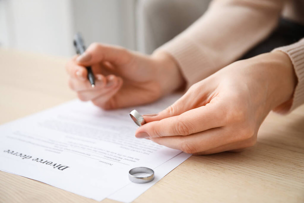 Женщина подписывает указ о разводе в офисе адвоката, крупным планом - Фото, изображение