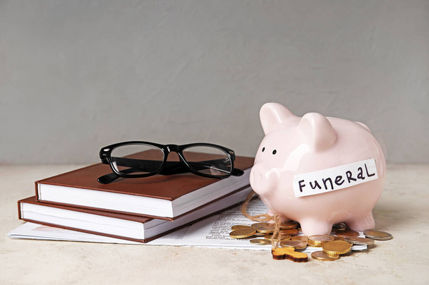 Piggy banco com dinheiro e livros sobre fundo leve - Foto, Imagem
