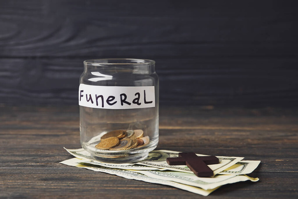 Jar with money and cross on dark wooden background - Foto, Imagem
