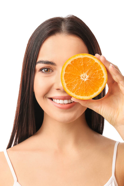 Beautiful young woman with orange on white background - Фото, зображення