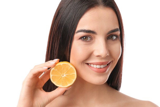 Beautiful young woman with lemon on white background - Photo, Image
