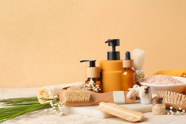 Composição com escovas de massagem, suprimentos de banho e flores no fundo de cor - Foto, Imagem