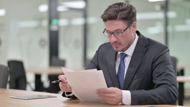 Средневековый бизнесмен читает документы в офисе  - Фото, изображение