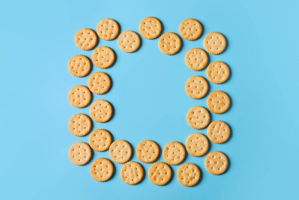 Frame made of tasty crackers on color background - Photo, Image