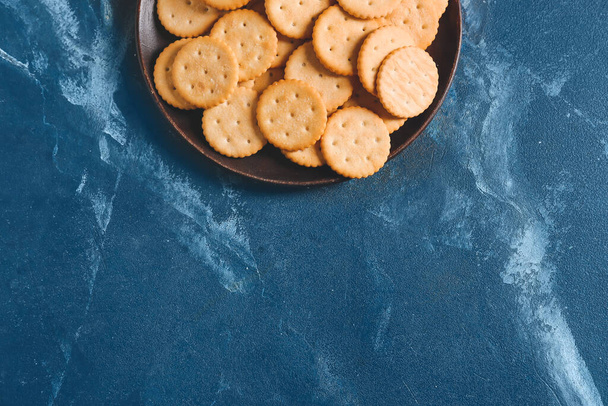 Plate with tasty crackers on color background - Photo, Image