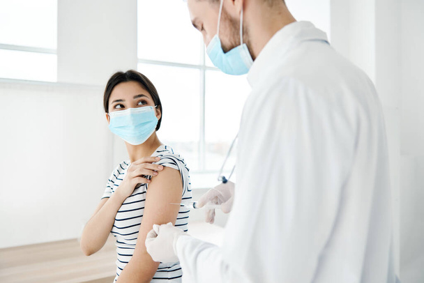 paziente femminile in maschera medica rende vaccino in ospedale sanitario - Foto, immagini