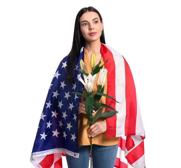 Young woman with USA flag and flowers on white background. Memorial Day celebration - Φωτογραφία, εικόνα