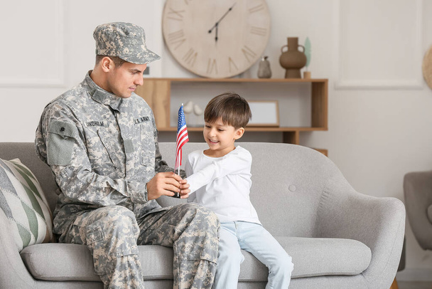Soldado y su hijito con bandera de USA en casa. Celebración del Día de Memorial - Foto, imagen