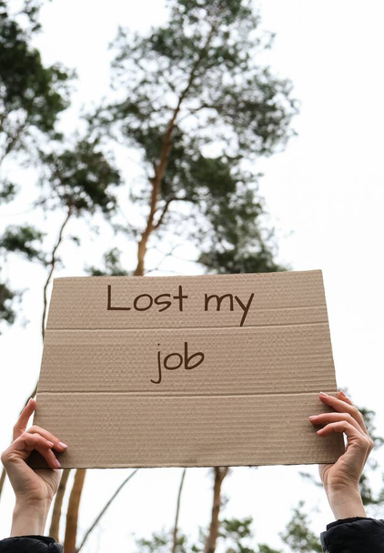 Ženské ruce držící karton s textem LOST MY JOB outdoors. Přírodní pozadí. Protester aktivista. Sociální aktivismus - Fotografie, Obrázek