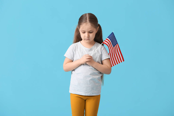 Little girl with USA flag on color background. Memorial Day celebration - Foto, Imagen