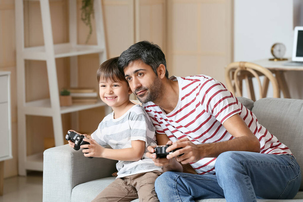 Father and little son playing video games at home - Foto, Imagem