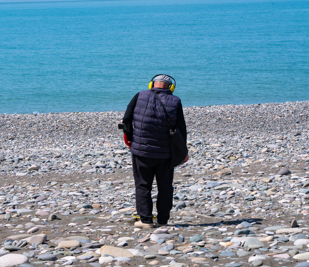 Batumi, Georgia - April 28, 2021: Man with a metal detector on the beach - Photo, Image