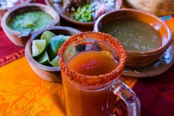 Bulanık arka planlı cam bardakta geleneksel Meksika Michelada 'sı. - Fotoğraf, Görsel