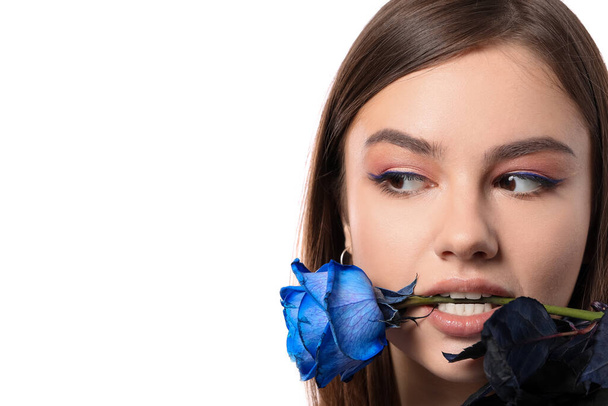 Mooie jonge vrouw met blauwe roos op witte achtergrond - Foto, afbeelding