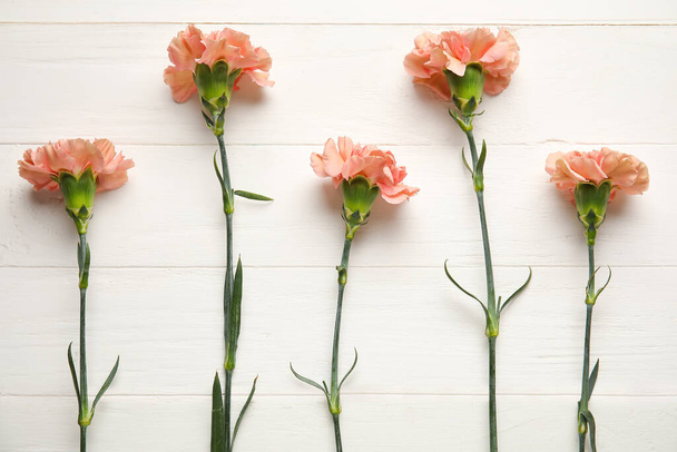 Fresh carnation flowers on white wooden background - Photo, Image